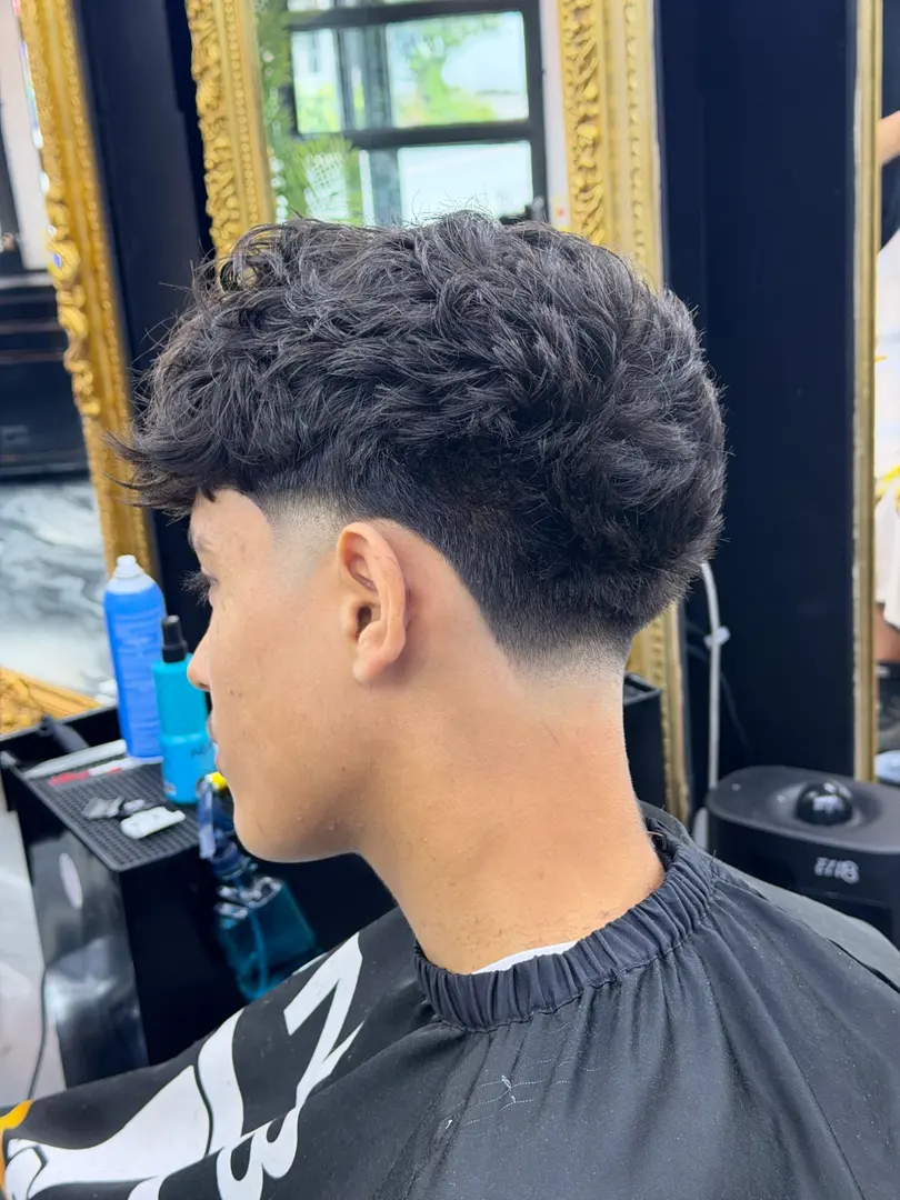 Cheveux ondulés texturés avec taper fade bas et nuque nette